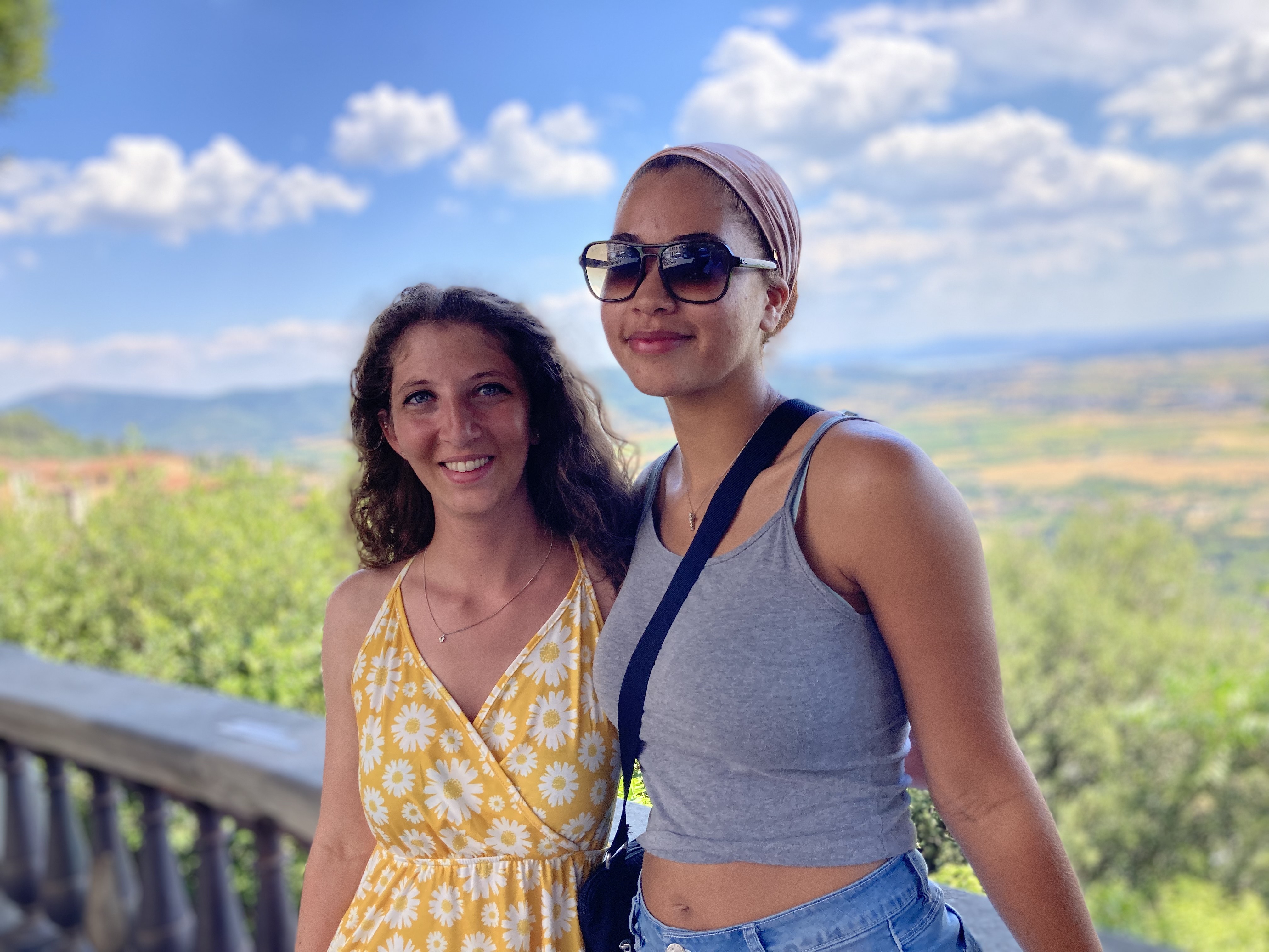 Two students on a trip abroad in the sunlight.