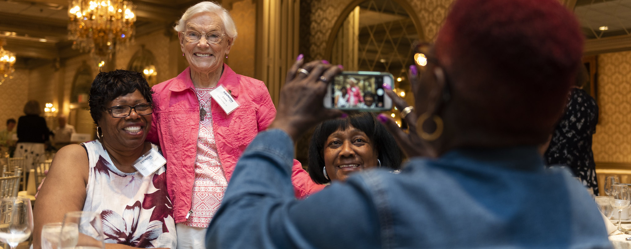 An SEU alumni takes a photo of her classmates at reunion.