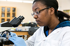 SEU science student looking through microscope